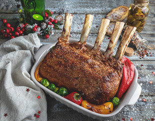 Grilled roasted rack of lamb chops with vegetables in ceramic baking dish. New Year christmas composition,decoration.