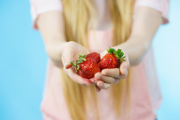 Girl showing fresh strawberries