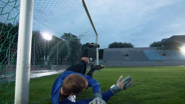 Soccer Goalkeeper Tries to Defend Goals but Jumps and Fails to Catch the Ball. Goal! In Slow Motion.
