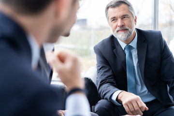 Group of business partners discussing ideas and planning work in office.