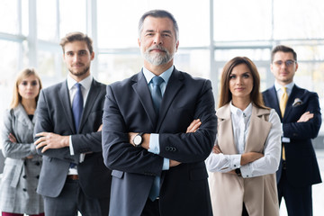 Happy business team with arms crossed at the office.