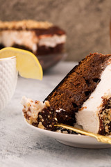 Chocolate cake on a plate with a spoon. Delicious dessert. Vertical. A slice of lemon on the edge of the Cup.
