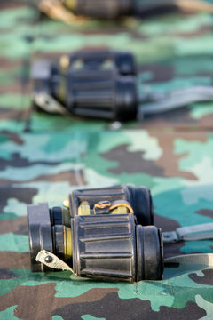 military binoculars on camouflage wallpaper