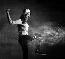 Young sport woman after workout exercise stand in cap on loft wall with dust snow splashes