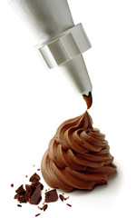 Whipped and swirl formed chocolate cream with icing bag isolated on white background