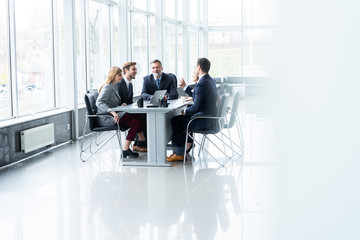 Businesspeople discussing together in conference room during meeting at office.