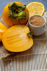 Delicious ripe persimmon fruit on wooden background