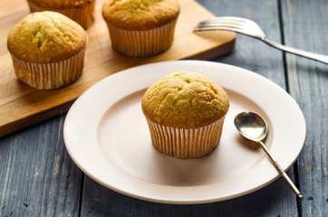 Muffin with cream and chocolate syrup. Cupcake with fresh raspberry berries. Cakes on the table. 