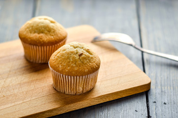 Muffins on a wooden board. Cakes on the table. Homemade pastries, delicious dessert.
