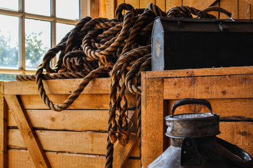 Old barn, hangar, boat, workshop with old rusty equipment, tool box, rope on a wooden boxes