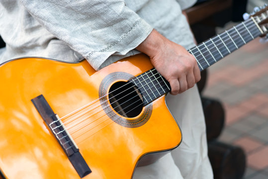 Acoustic yellow classical guitar in a man's hand