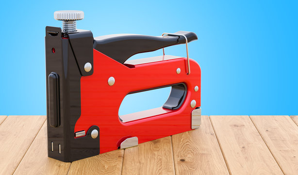 Staple gun on the wooden table. 3D rendering