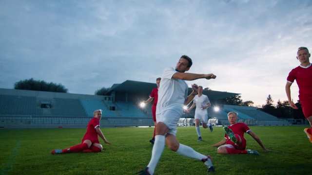 Professional Soccer Player Outruns Members of Opposing Team and Kicks Ball and Scores Goal. His Team Celebrates Victory. Cinematic Slow Motion.