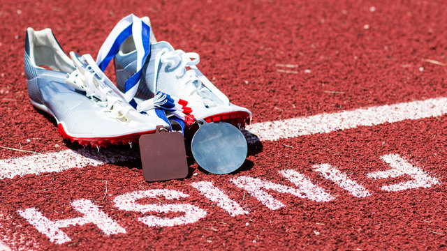 Track Spikes With Medals At The Finish Line