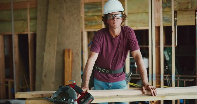 Medium wide orbit of attractive male carpenter looking into the camera