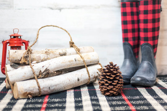 Rustic winter background with boots, logs and pinecone