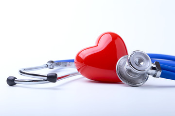 Medical stethoscope and red heart isolated on white.