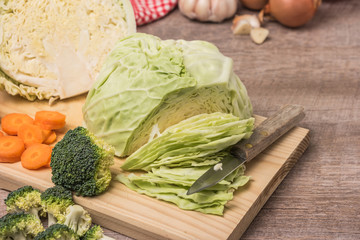 Fresh vegetables from the garden, carrots, cabbage, broccoli, onion and garlic on a wooden table