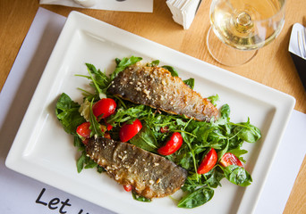 Delicious seared fish fillet with wine on restaurant background.
