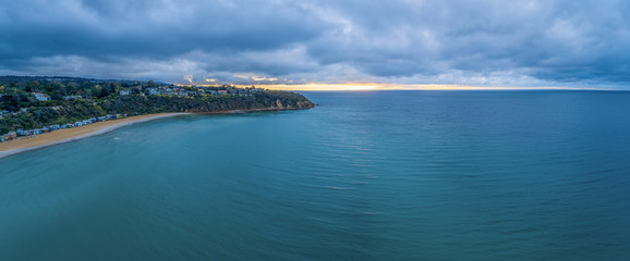 Aerial panorama of Mount Martha beach and cliff with bathing boxes at sunset