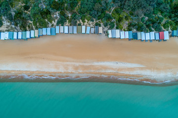 Looking down at beach huts sandy beach, and turquoise bay water at Mount Martha, Melbourne, Australia