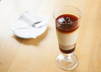 Cheesecake with caramel sauce in a long glass with chocolate details
