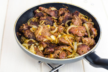 Frying pan with fried chicken giblets. Studio Photo