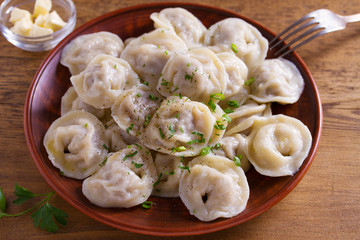 Dumplings, filled with meat, ravioli. Traditional Russian dish pelmeni. Dumplings with filling. View from above, top studio shot