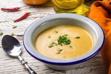 Seasonal autumn food - Spicy pumpkin soup with cream and pumpkin seeds.