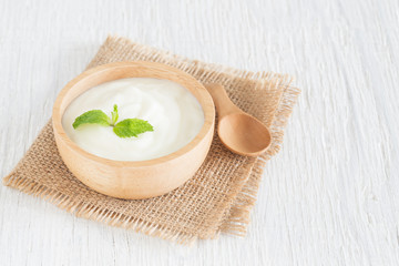 Obraz na płótnie Canvas Yogurt in wood bowl on white wooden table Healthy food concept