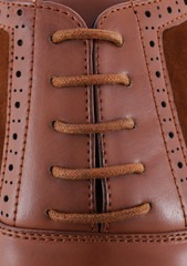 Brown leather men's shoewith brown laces close-up