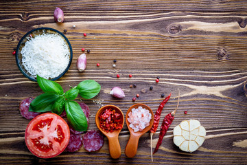 The ingredients for homemade pizza on shabby wooden background.