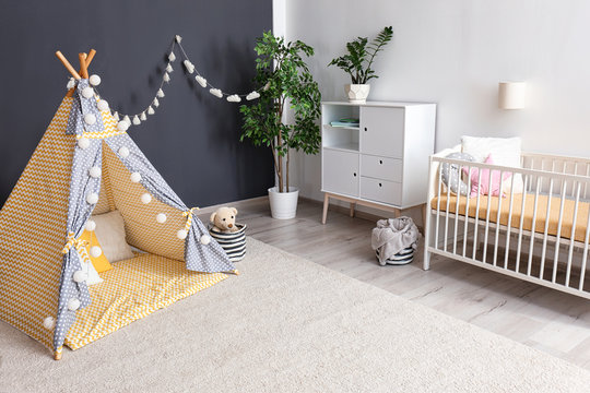 Cozy baby room interior with play tent and toys
