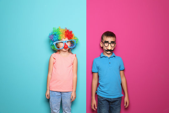 Children in funny disguise ready to celebrate April Fool's day on color background