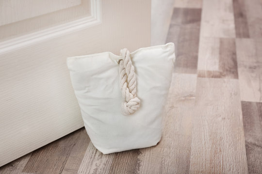 Stuffed bag holding wooden door at home