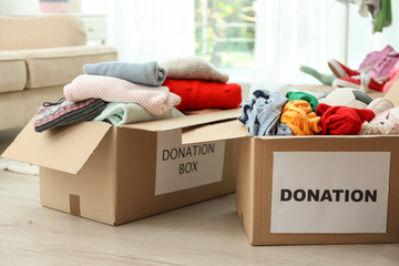 Donation boxes with clothes on floor indoors