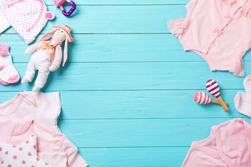 Flat lay composition with stylish baby clothes and toys on wooden background. Space for text