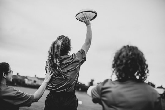 Female rugby player throwing a ball - Powered by Adobe