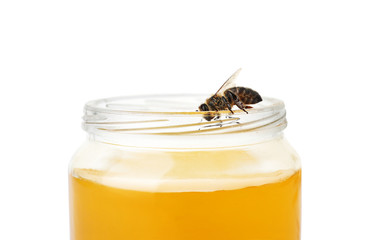 Jar with honey and bee on white background