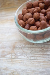 Hazelnuts in a glass jar in the background of the tree. Copy space.