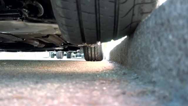 Bad car parking with half tire on the curb at risk of damage
