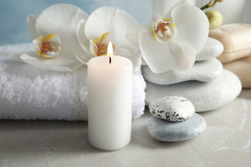 Fototapeta na wymiar Beautiful composition with candle and spa stones on light table