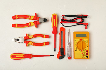 Flat lay composition with electrician's tools on light background