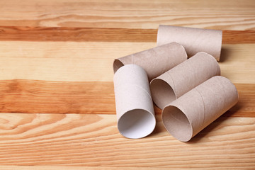Empty toilet paper rolls and space for text on wooden background