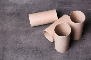 Empty toilet paper rolls and space for text on gray background