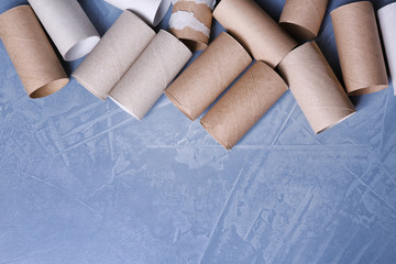 Empty toilet paper rolls and space for text on color background, top view