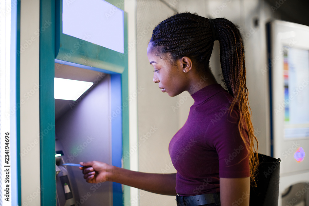 Wall mural Woman withdrawing money from a cash machine