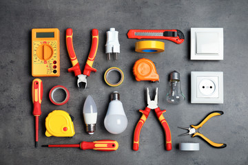 Flat lay composition with electrician's tools on gray background