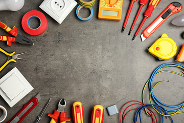 Flat lay composition with electrician's tools and space for text on gray background