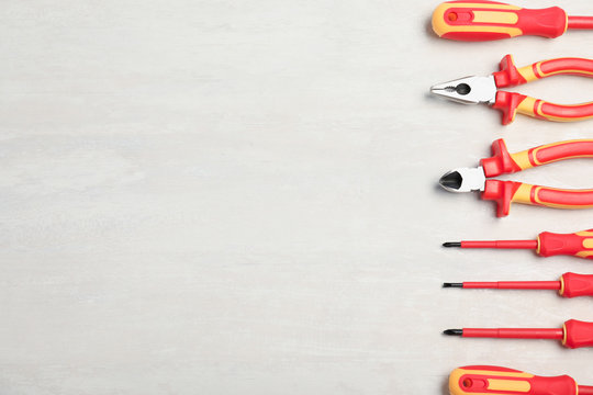 Flat lay composition with electrician's tools and space for text on light background